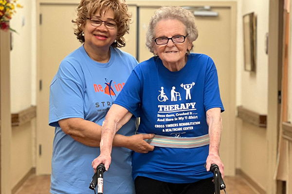 Nexion employee walking with elderly woman during physical therapy session