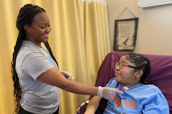 Nexion employee working with patient on respiratory