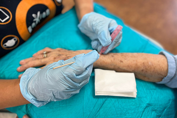 Nexion employee wrapping patient wrist with bandage