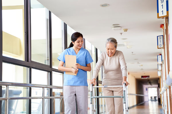 Nurse walking down hallway with patient