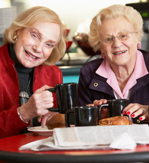 two elderly woman drinking coffee