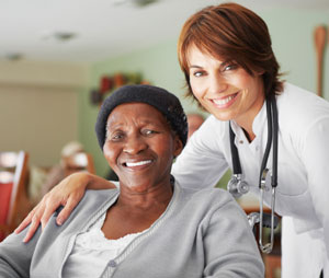 young female caregiver with her arm around elderly woman's shoulder