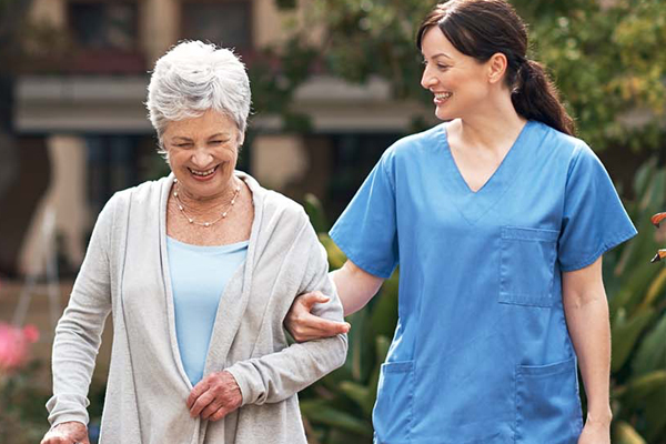 Nurse walking outside with older woman